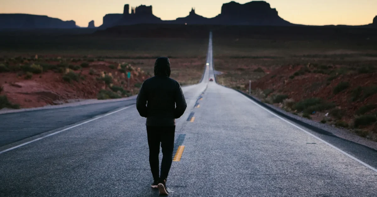 A guy walking on the road as an exercise.