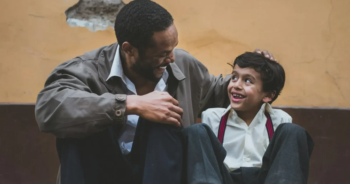 A father and son smiling to see each other.