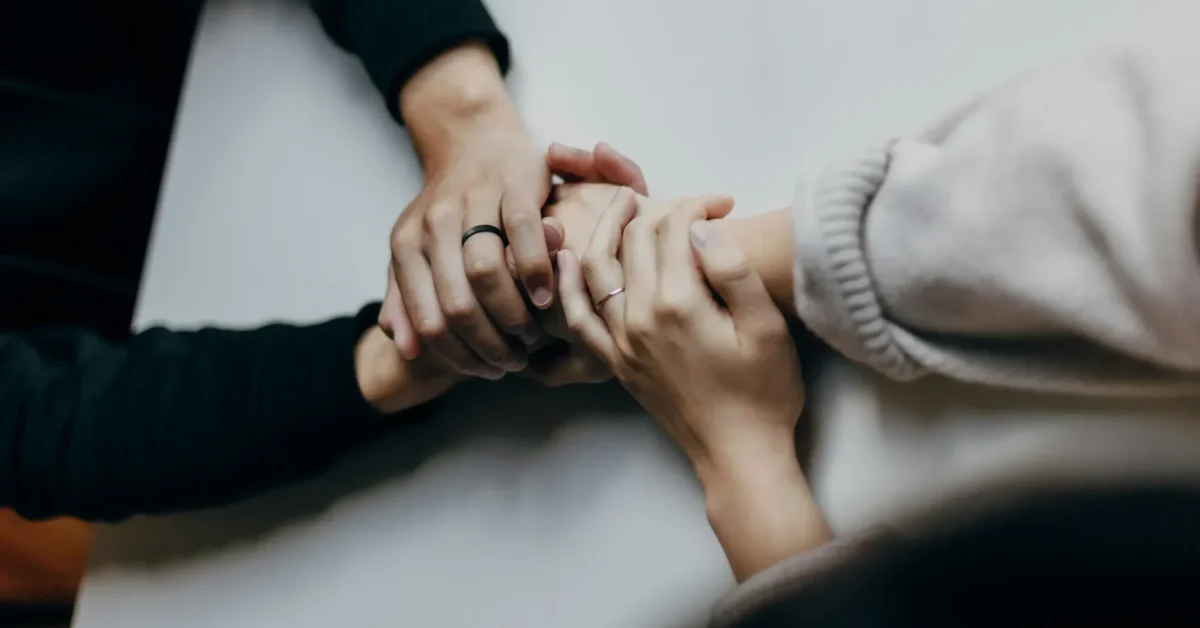 2 persons supporting each other by holding hands of each others.