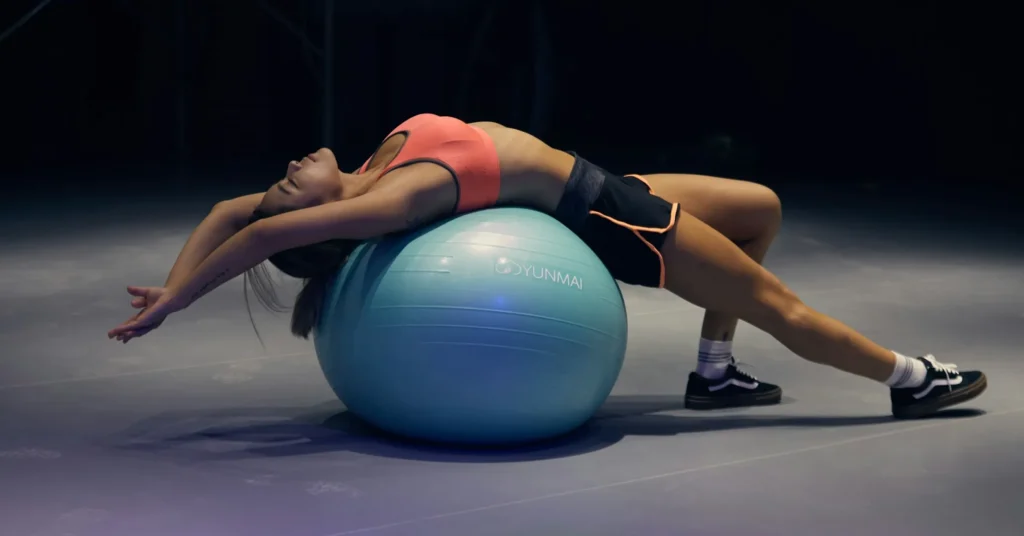Best exercises for faster weight loss. A girl in this picture exercising by using a baloon.