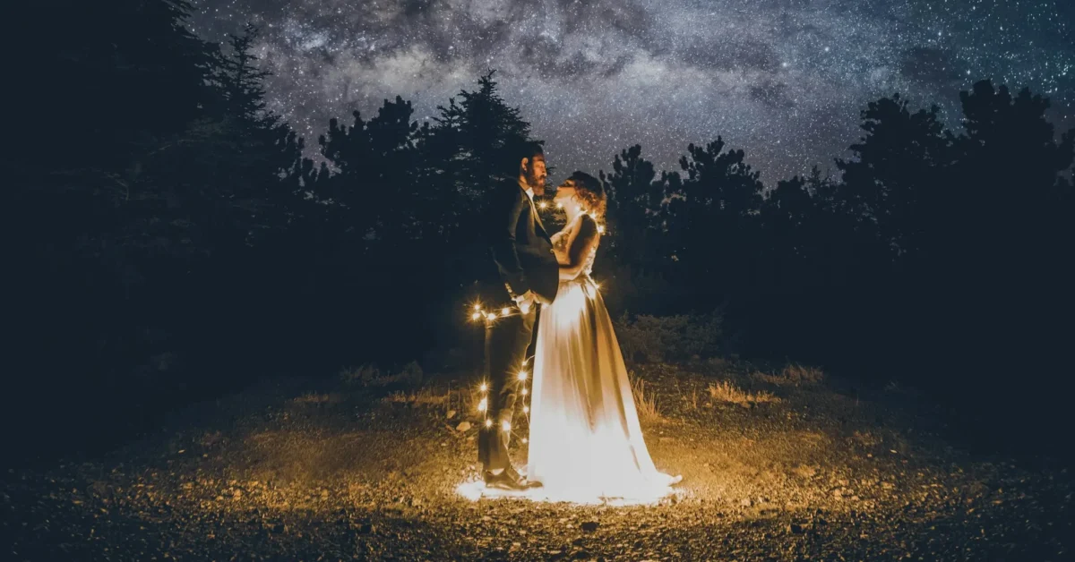 A man holding his wife with love in the dark under the dark sky.