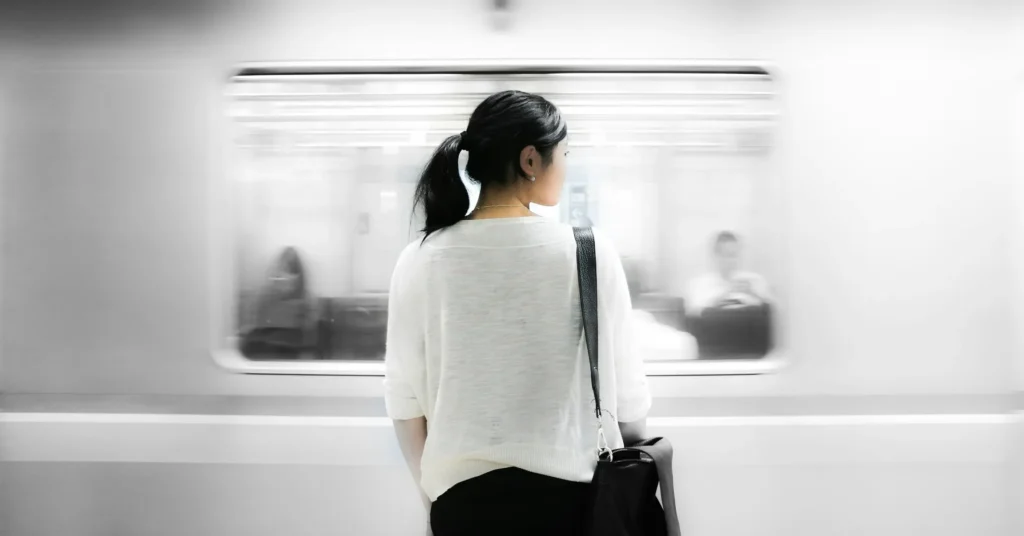 A girl standing and a train is passes in front of it showing the changes with time.