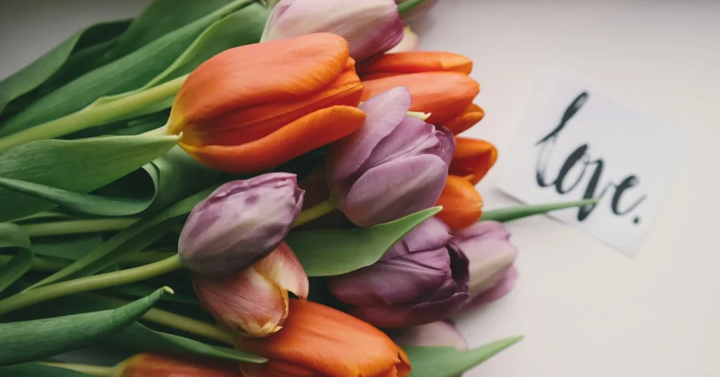 A bouquet of flowers and a card on which love is written