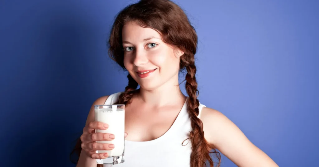 A girl holding a glass of milk to highlight it's importance.