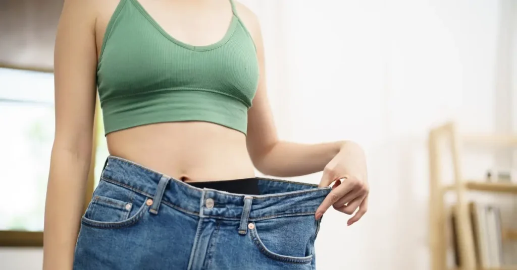A girl showing her loose pent to show the slim body.