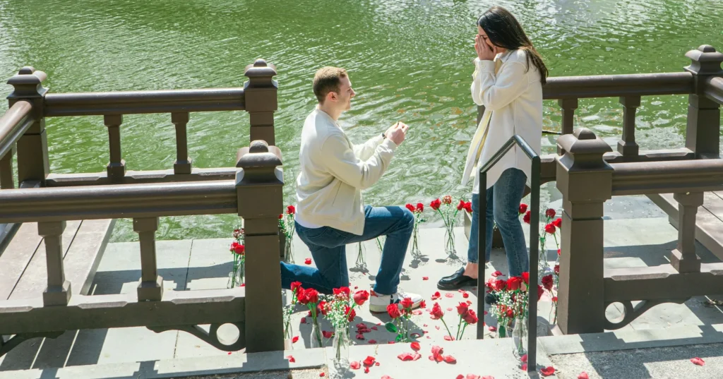 Teen boy proposing a girl beside a lake.